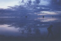 写真展「DEAR」より。空と波だけを写した作品郡の中で唯一、風景全景を写した。右下のシルエットは撮影旅行を共にした息子。2016年撮影。（写真提供：アミタマリ）