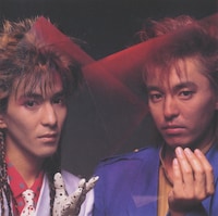 1984年デビュー当時の小室哲哉（左）と宇都宮隆。小室の風貌はCulture Clubのボーイ・ジョージを彷彿させる。（出典：「World Heritage」附録ブックレット / ソニーミュージックエンタテインメント）