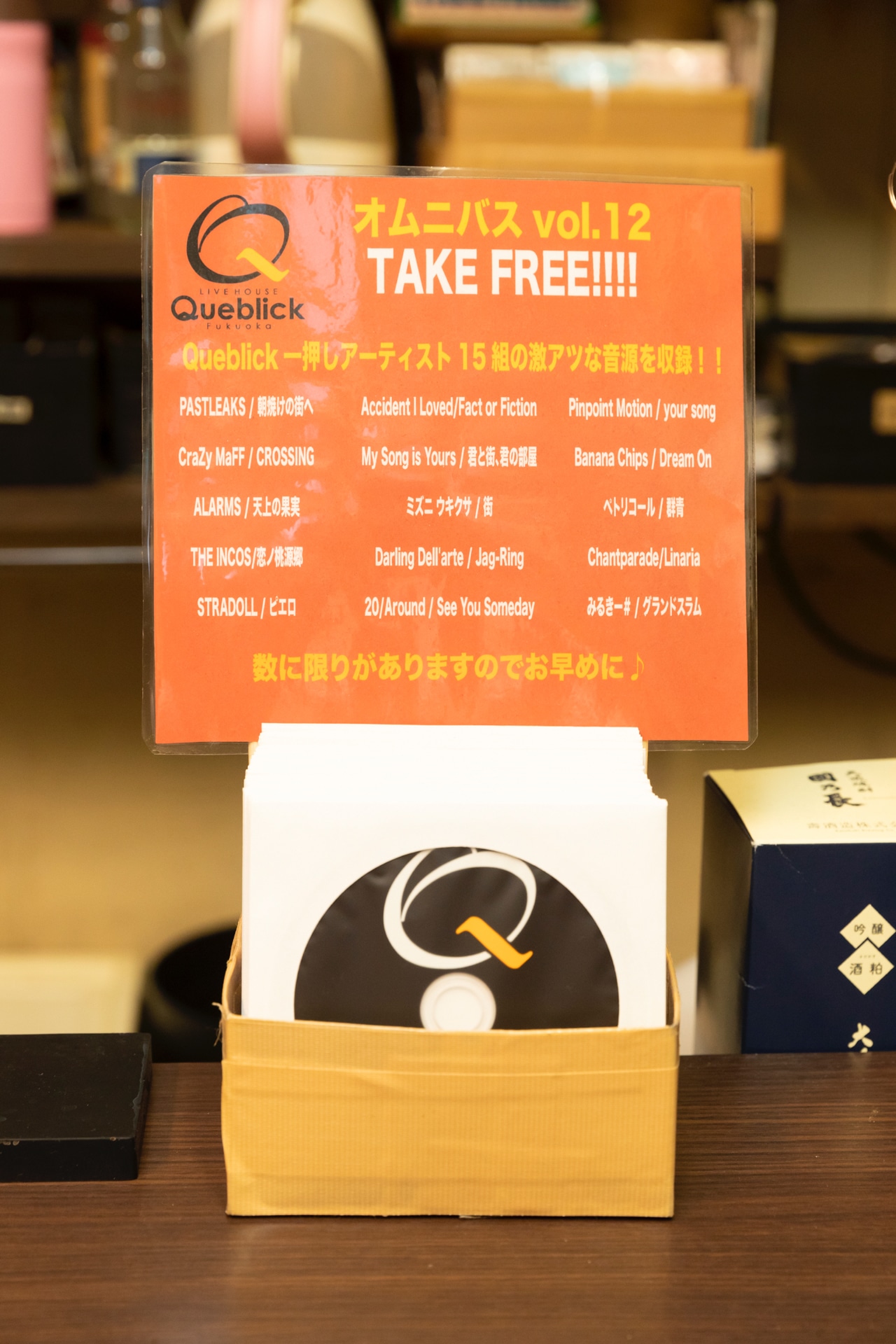 バーカウンターの上で配布されているQueblick制作の無料オムニバスCD。