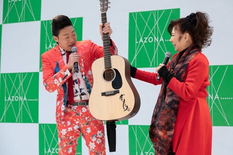 八代亜紀からアコースティックギターを受け取るみやぞん。（Photo by Tomokazu Tazawa）