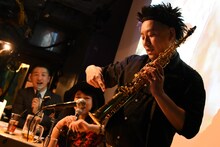 サックスを持ったパフォーマンスについて説明するレイザーラモンRG。
