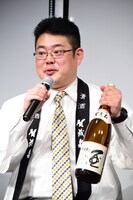 賀茂泉酒造自慢の日本酒「純米吟醸　朱泉本仕込」をアピールする前垣壽男氏。
