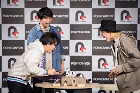 紙相撲で勝負する阿部敦と山田義孝(Vo)。(撮影:星野耕作)