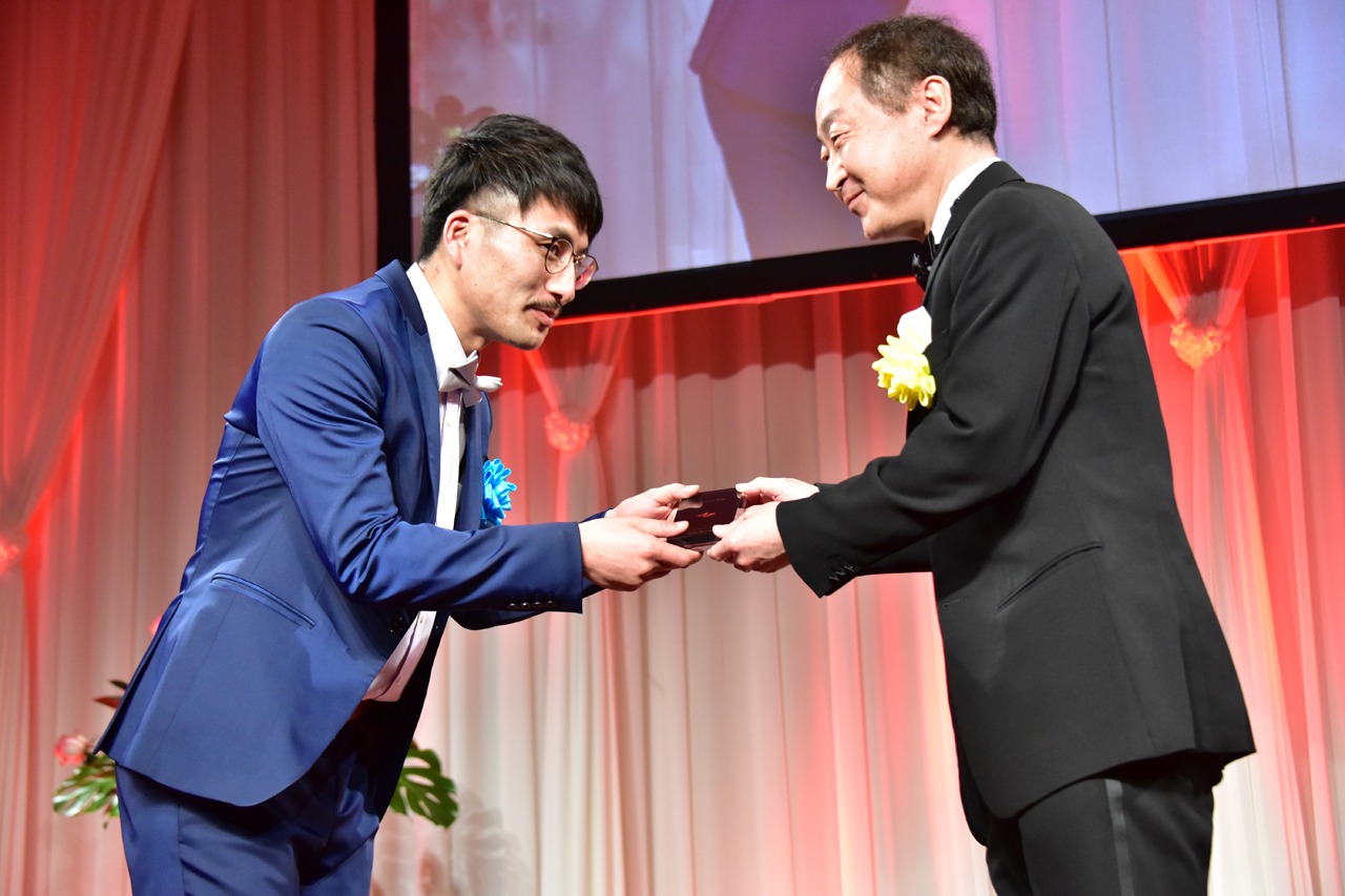 モノリスを受け取る魂の巾着・本多（左）。