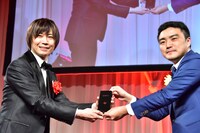 モノリスを受け取る前田裕二氏（左）。