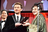 一般社団法人デジタルメディア協会の襟川恵子理事長からモノリスを受け取るDA PUMPのISSA（左）。