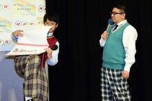 フリップをめくるのに手間取るミキ亜生（左）とそれを待つミキ昴生（右）。