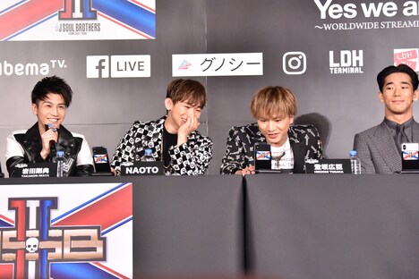 イベントの様子。岩田剛典(左)のコメント中も配信画面に向かってアピールするNAOTO(左から2番目)、登坂広臣(左から3番目)と、2人を気にする小林直己(右)。