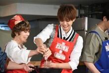 平野レミ（左）に手伝ってもらいながら油をフライパンに注ぐ片寄涼太（右）。