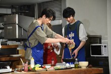 菜箸を使ってフライパンに静かに卵液を流し込む町田啓太（左）。