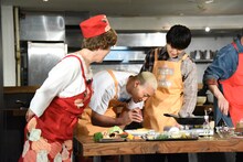 オムライスにケチャップで文字を書く関口メンディー（中央）を見守る平野レミ（左）と佐野玲於（右）。