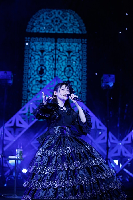 黒いドレス姿で歌う上坂すみれ。