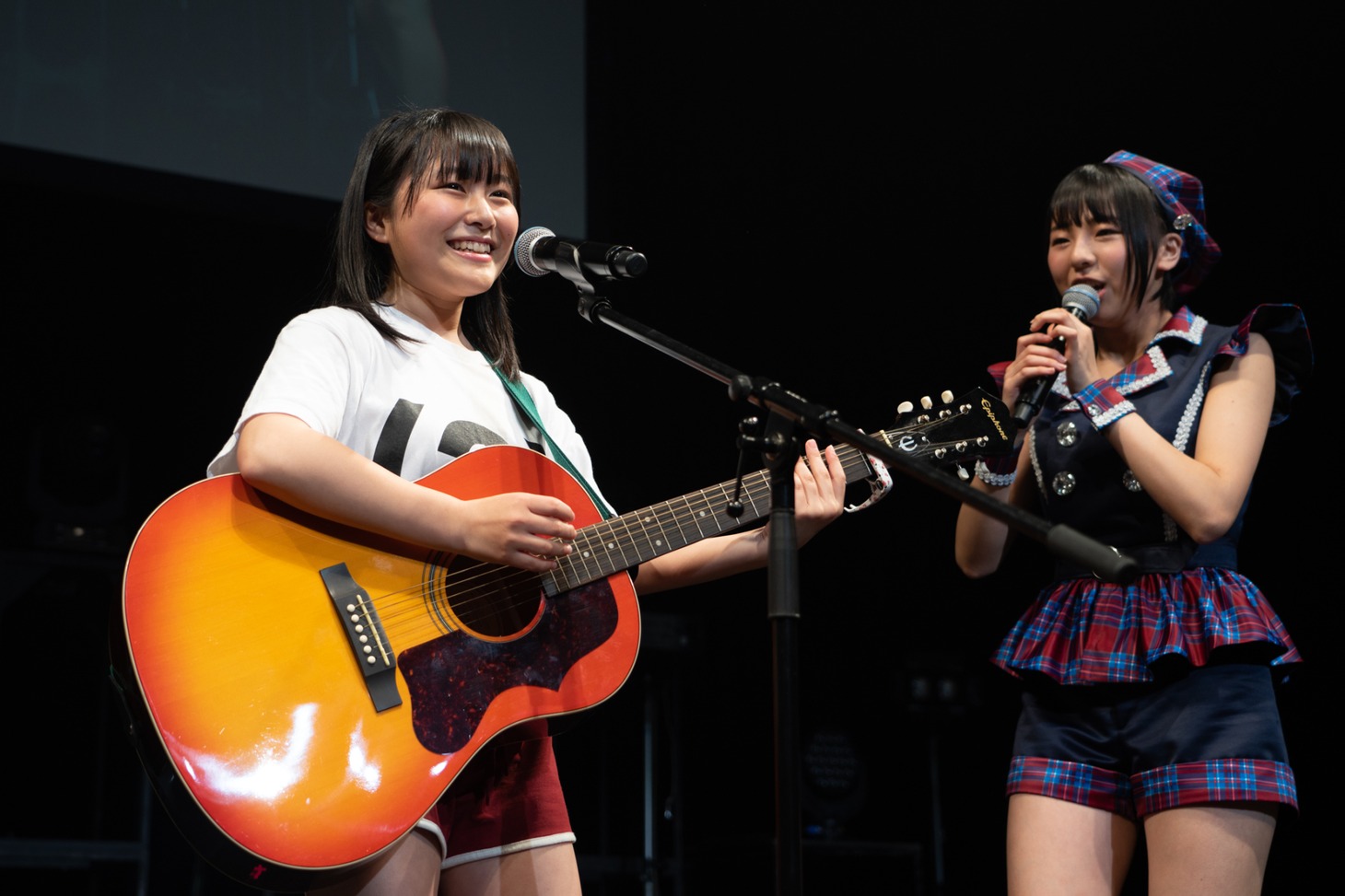 アコースティックギターの弾き語りを披露する島崎友莉亜。