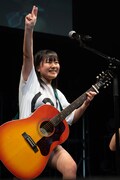 アコースティックギターの弾き語りを披露する島崎友莉亜。
