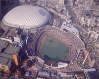 1987年（昭和62年）後楽園球場の脇で建設が進む東京ドーム。オープン後は大規模な音楽イベントも催され、日本武道館に並ぶ音楽の聖地となる。（写真提供：株式会社東京ドーム）