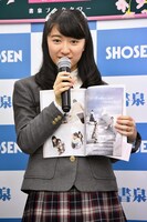 写真集のお気に入りのカットを見せる日高麻鈴。