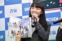 写真集を広げる麻生真彩。