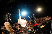 終演後に長谷川プリティ敬祐のベースを掲げる3人。(撮影:ハタサトシ)
