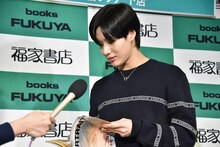 お気に入りの写真が掲載されたページを開くテミン。