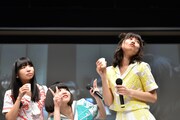 カメラに向かってアイドルらしくアピールする鹿目凛（右）と野次馬の古川未鈴（左）、根本凪（中央）。