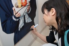 パネルにサインを書き入れる中山莉子。