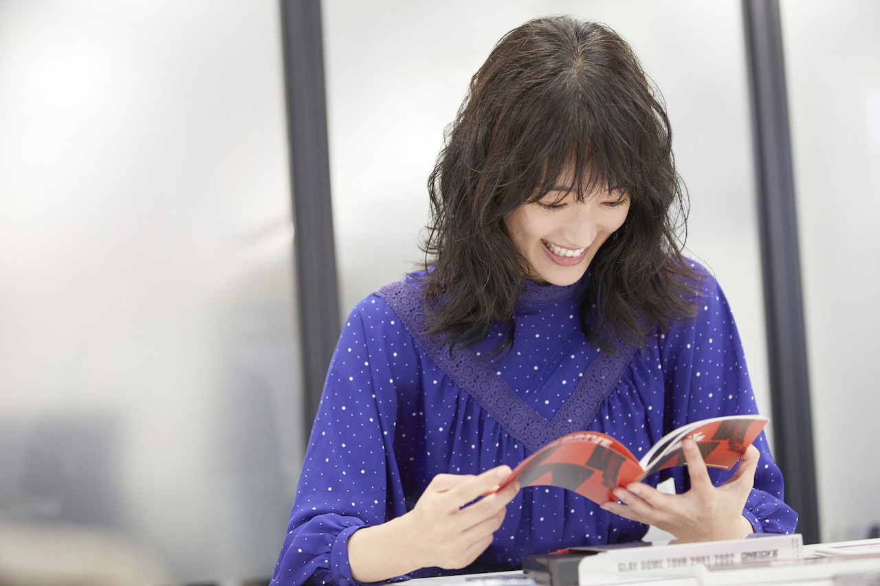 「DRIVE」のライナーノーツを広げる入山法子。