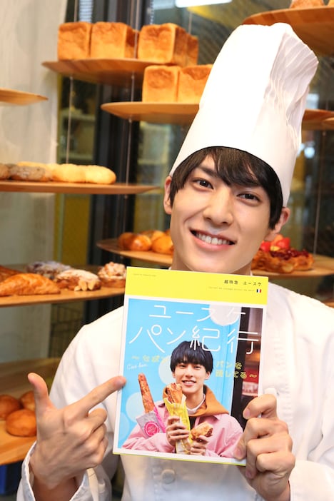 ソロ写真集「超特急ユースケ パン紀行」を手に、笑顔のユースケ。