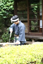 ノコギリで木材を切る棟梁のユースケ。