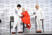 椅子に座るLISAをサポートする☆Taku Takahashi（左）とVERBAL（右）。