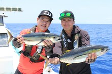 キハダマグロを手に喜ぶ原西孝幸（左）、山下健二郎（右）。 (c)テレビ新広島