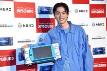 「JOYSOUND MAX GO」を小脇に抱える菅田将暉。