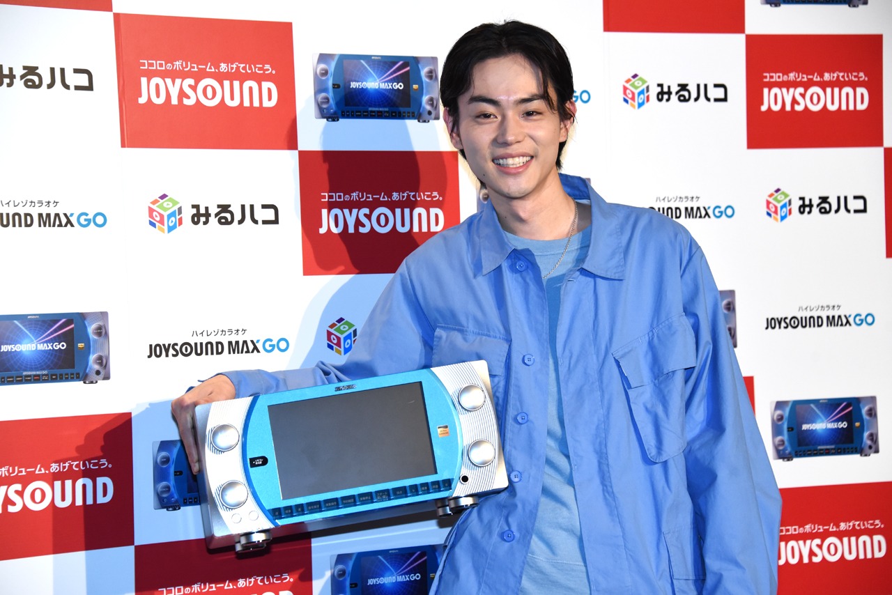 「JOYSOUND MAX GO」を小脇に抱える菅田将暉。
