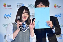 「JOYFUL LOVE」のミュージックビデオで着用している衣装と同じ色のバインダーの横でピースする渡邉美穂（日向坂46）。