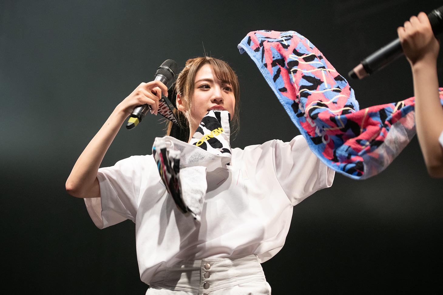 両手と口を使ってグッズを紹介する志田友美。