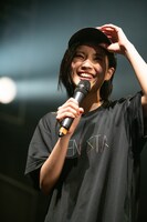 ツアーグッズのキャップを紹介する小林れい。