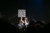 ファンクラブ入会用のQRコードを掲げるそれいゆ（Vo, Glocken）。（撮影：狐塚勇介）