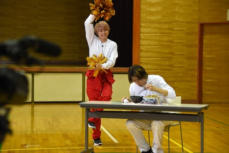 大食いチャレンジに挑むタカシ（右）とタカシを応援するユーキ（左）。