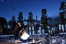 モニュメントを叩きながら庭園の説明を行う山口一郎（NF、サカナクション）。