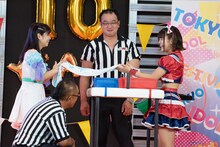 アップアップガールズ（2）の高萩千夏（左）が持参したタオルで汗を拭うchuLaの夏目みさき（右）。