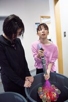 客席に投げる水風船を自ら作る真山りか（右）とその様子をじっと見る小林歌穂（左）。