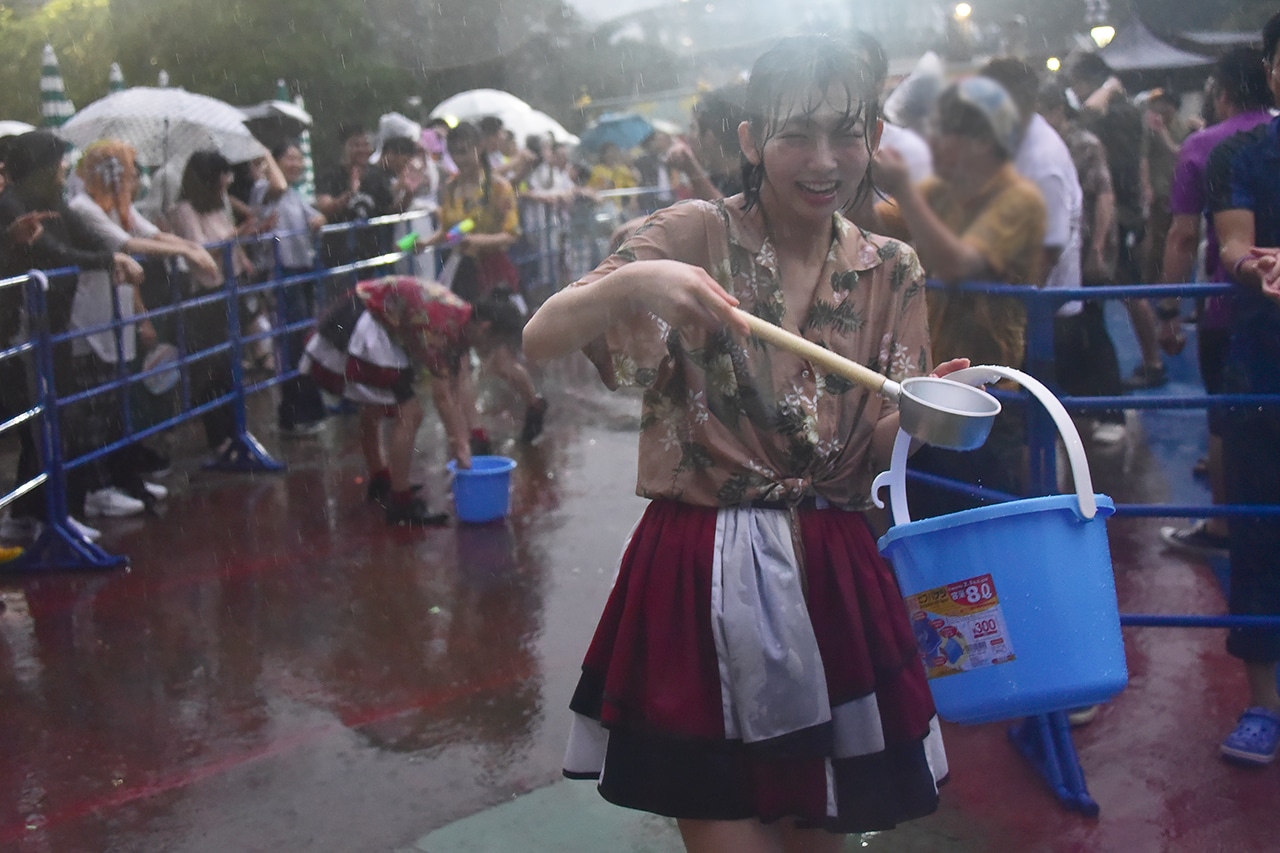 ひしゃくでバケツから水をすくう水春。