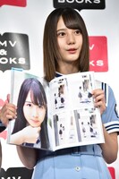 お気に入りの1枚のページを開く小坂菜緒。