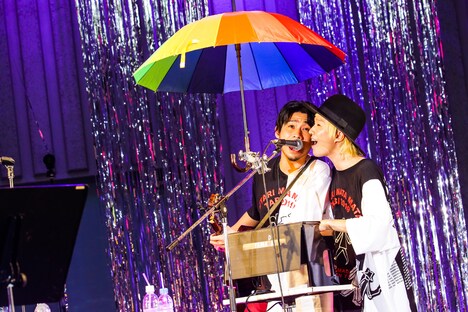 肩を寄せ合って1つのマイクに向かう吉田山田。