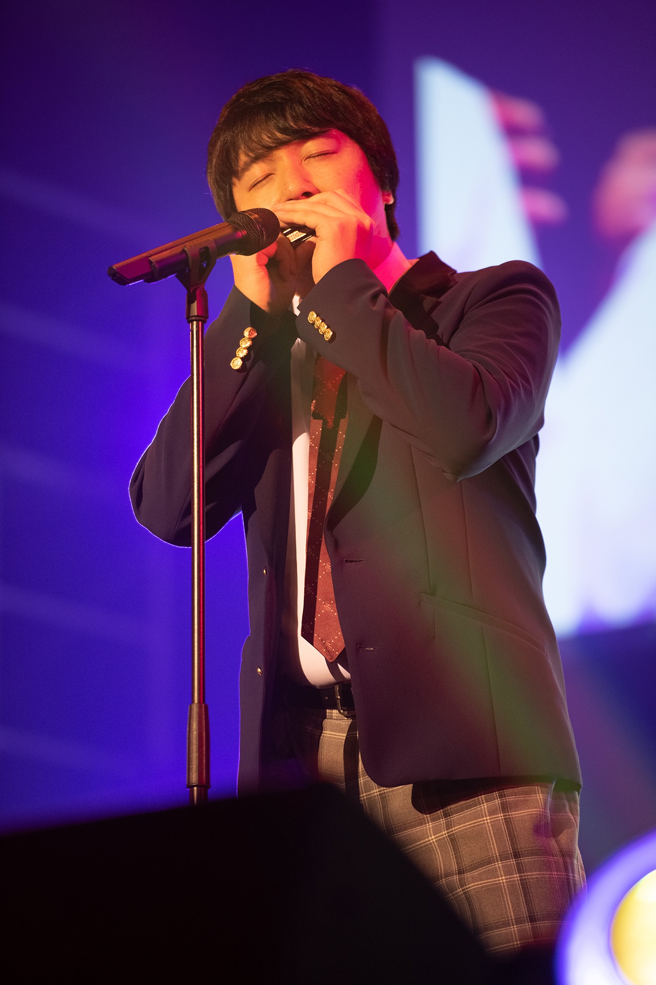 生徒に隠れて練習したブルースハープ演奏を披露する相田周二（三四郎）。