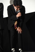 膝を抱えて笑う星野源。