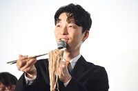 金色の箸で蕎麦を持ち上げる星野源。