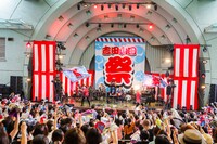 ステージ上で旗を振り回す吉田山田。