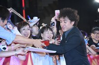 観客のサインのリクエストに応じるムロツヨシ。