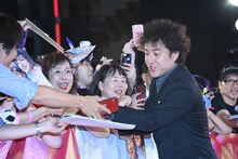 観客のサインのリクエストに応じるムロツヨシ。