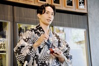 会計に用いる札を手にする橘ケンチ。札には江戸時代の目黒の風景が描かれている。